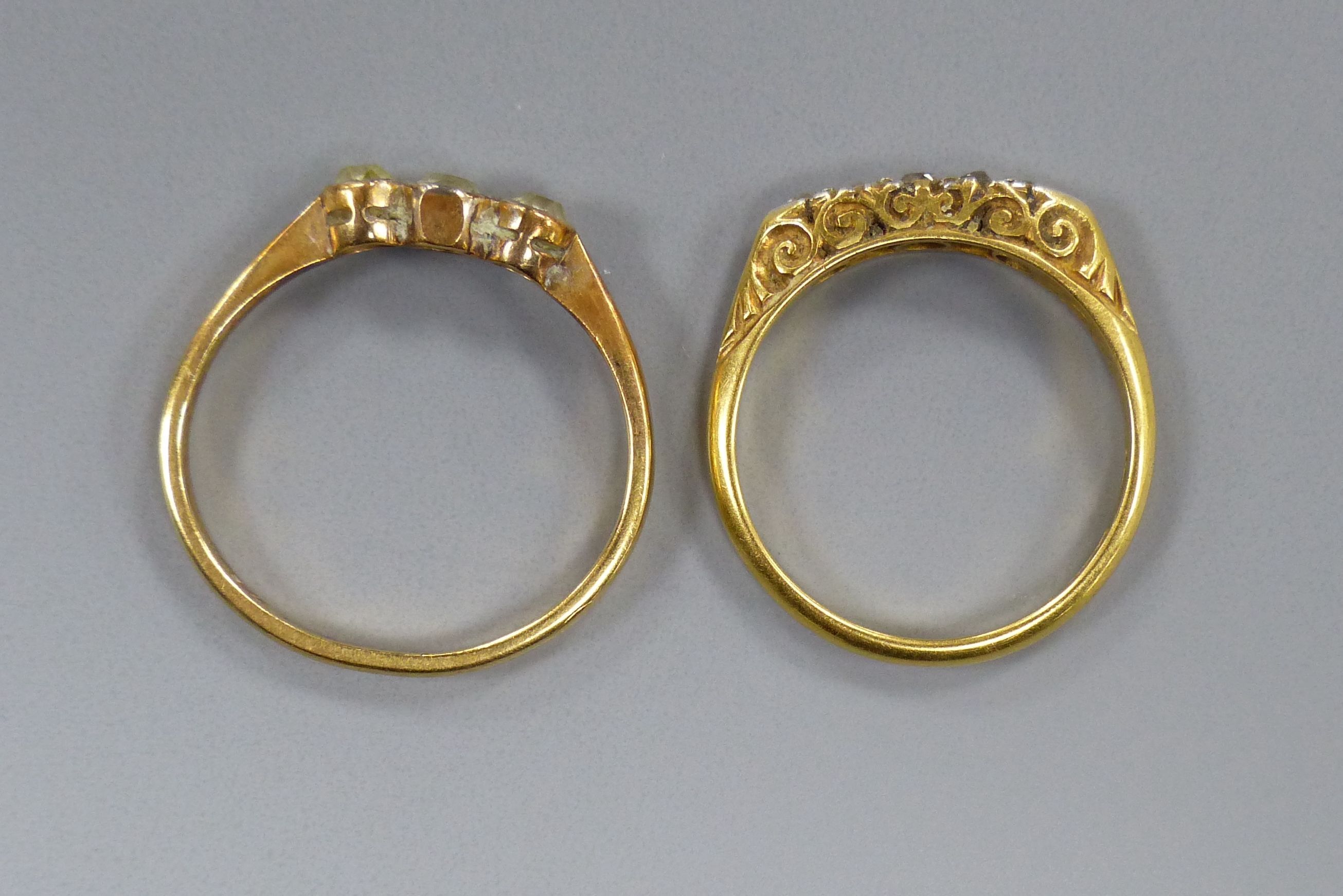 An 18ct gold three-stone diamond ring and another similar ring, gross 5.2 grams.